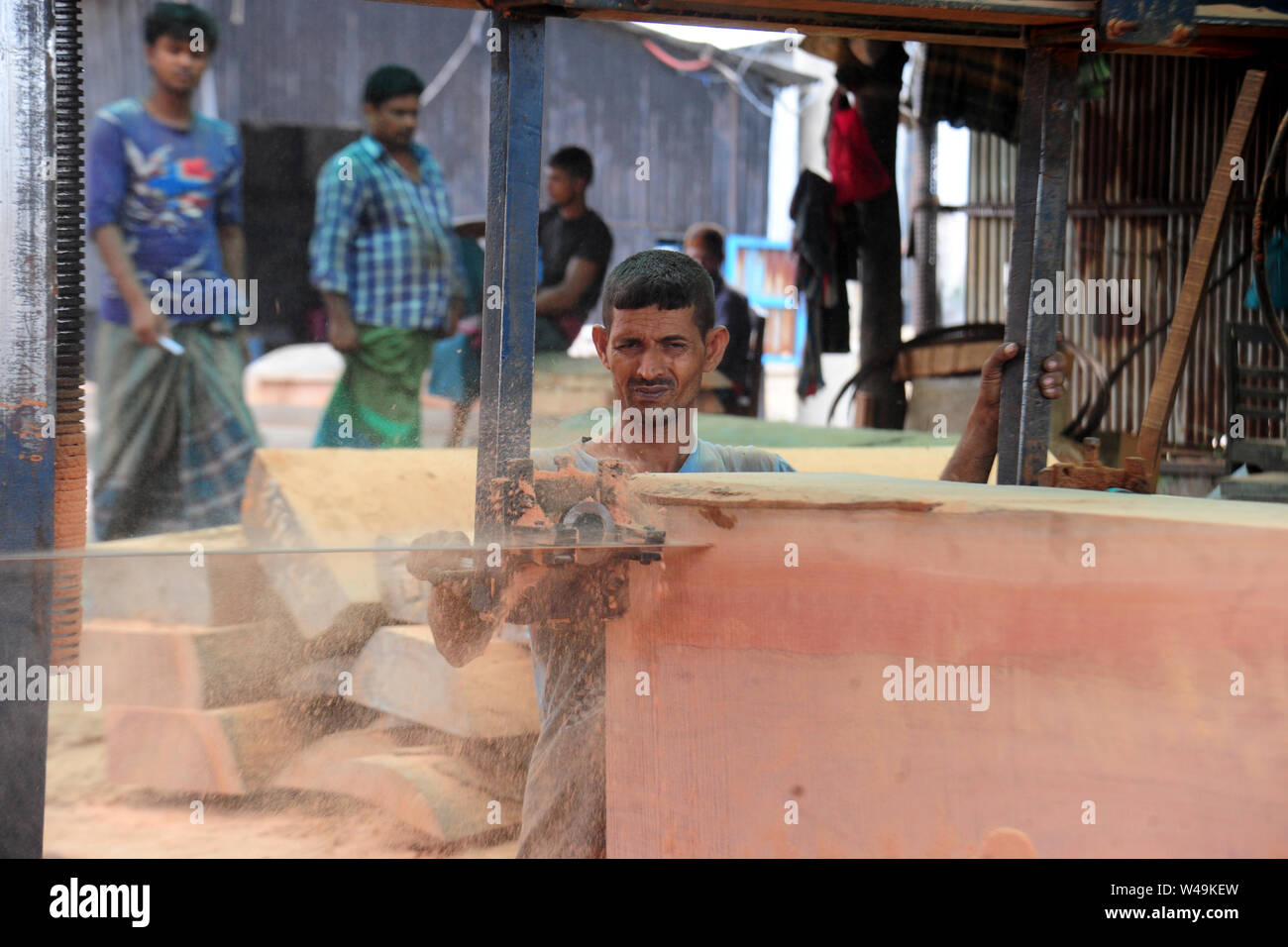 Bangladeshi worker processing wood in a saw mill near Dhaka in