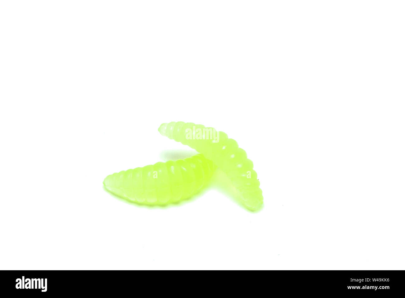Green Artificial fishing larvae of insects on white background with soft shadow. Stock Photo