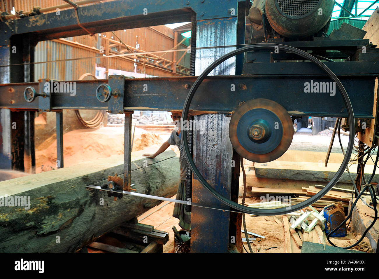 Bangladeshi worker processing wood in a saw mill near Dhaka in