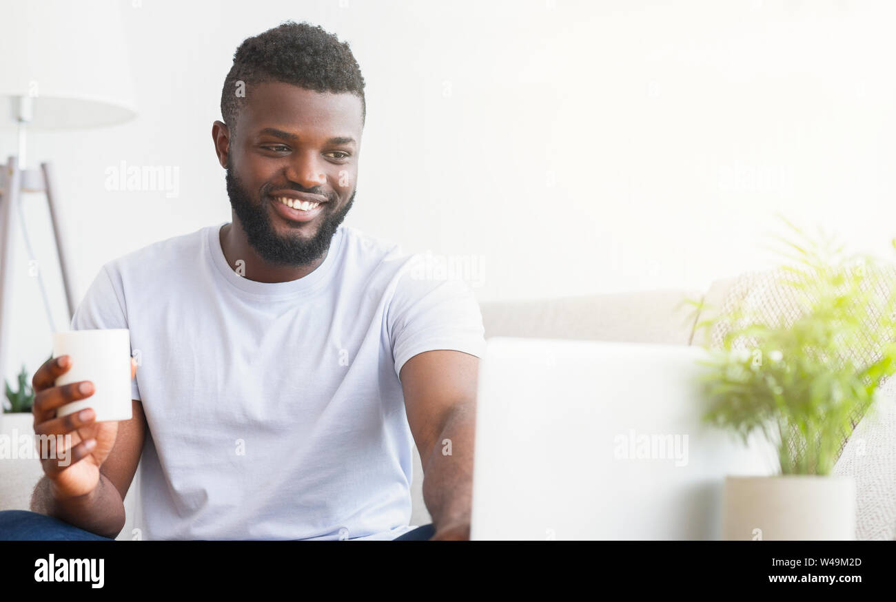 Young man using laptop, having video chat Stock Photo