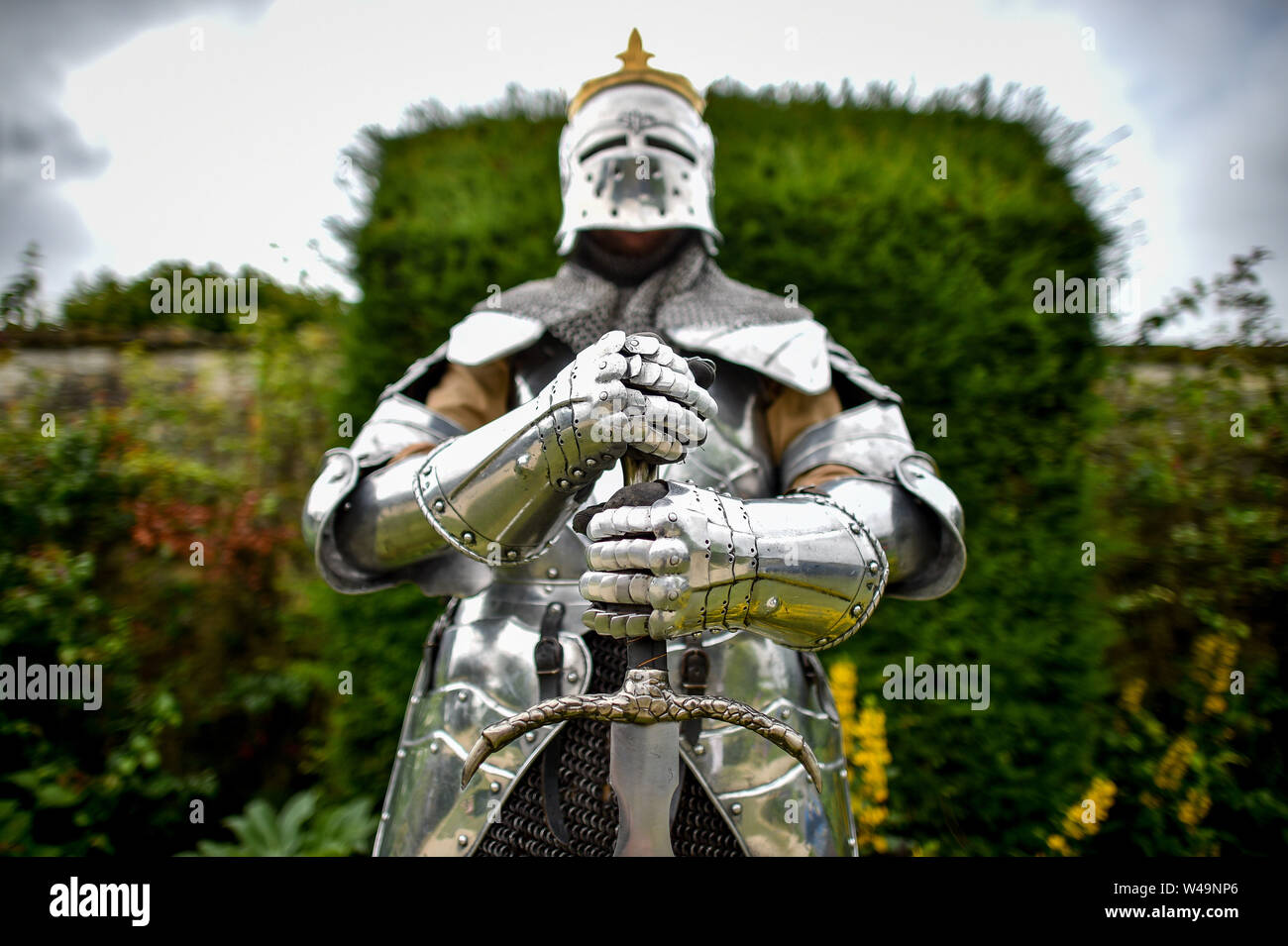 A knight in full metal armour takes a break during the Fantasy Forest weekend at Sudeley Castle, Gloucestershire, where hundreds of people have come together for the weekend to celebrate all fantasy genres. Stock Photo