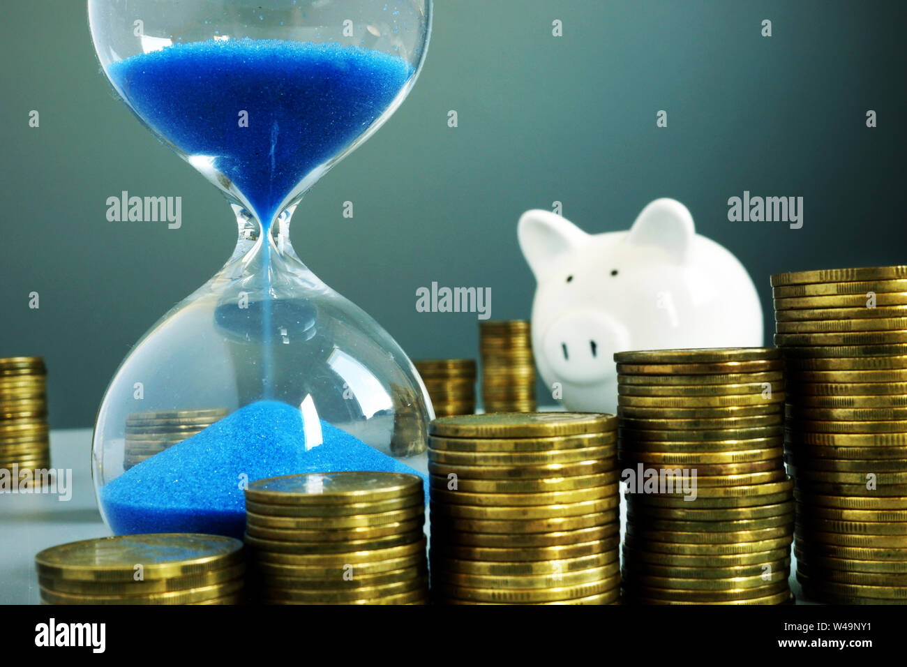 Sand clock, piggy bank and money. Bank deposit and savings. Stock Photo