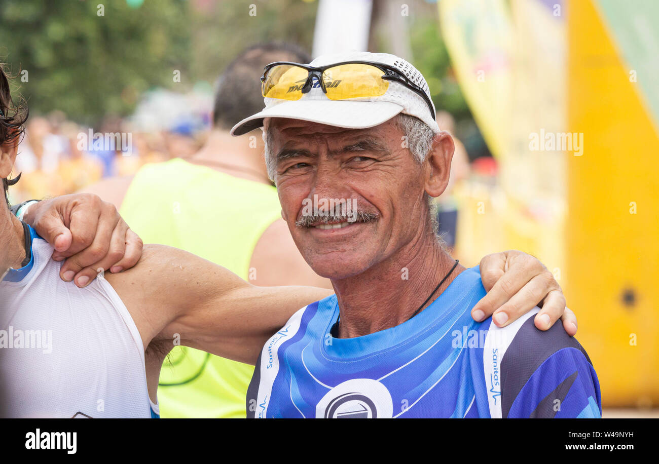 Las Palmas, Gran Canaria, Canary Islands, Spain, 21st July, 2019. Yiannis Kouros, a 63 year old ultramarathon world record holder, taking part in a 24 hour race for relay teams and individuals on a 1km circuit in Las Palmas on Gran Canaria. Considered by many to be one of the all time great ultra distance runners, he still holds world records for most distance covered in 24 hours (188.58 mi/303.506 km, in 1997), 48 hours (294.212 mi/473.495 km in 1996), 6 days (644.10mi/1036.80km in 2005)... Credit:Alan Dawson/Alamy Live News. Stock Photo