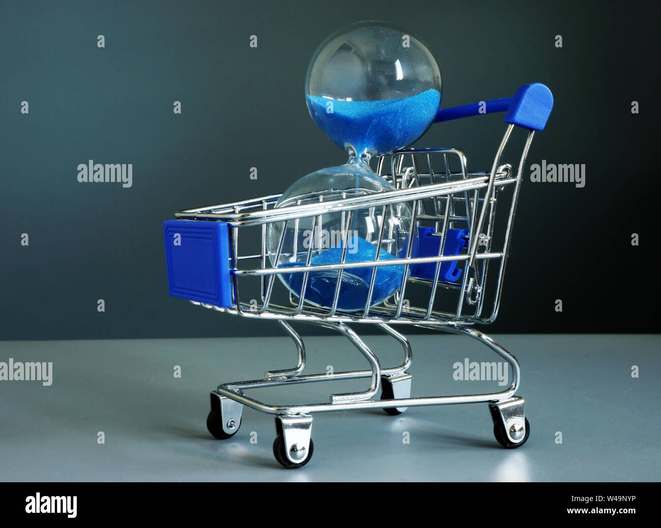 Buy time concept. Shopping cart and hourglass. Stock Photo