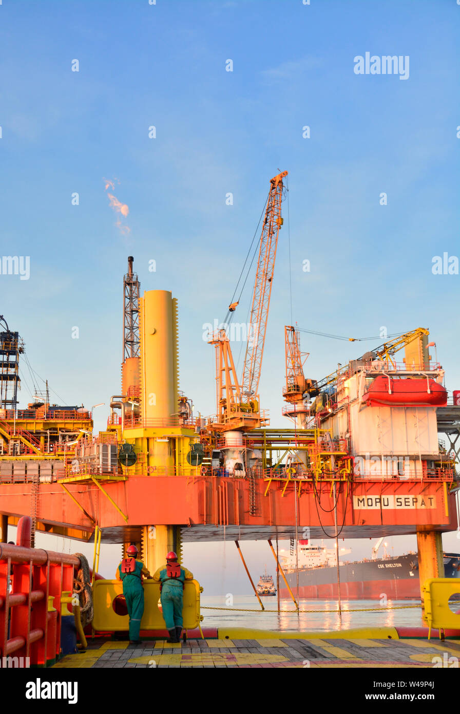 ship crew working on deck during transfer oil platform personal to vessel by safety basket operate by crane operator Stock Photo