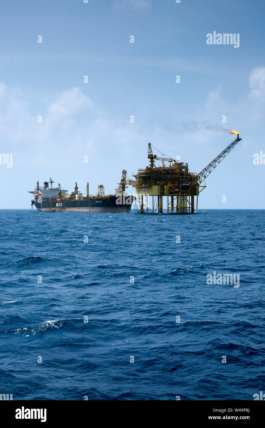 floating storage tanker or FPSO connected to oil platform at sea with beautiful blue sky Stock Photo