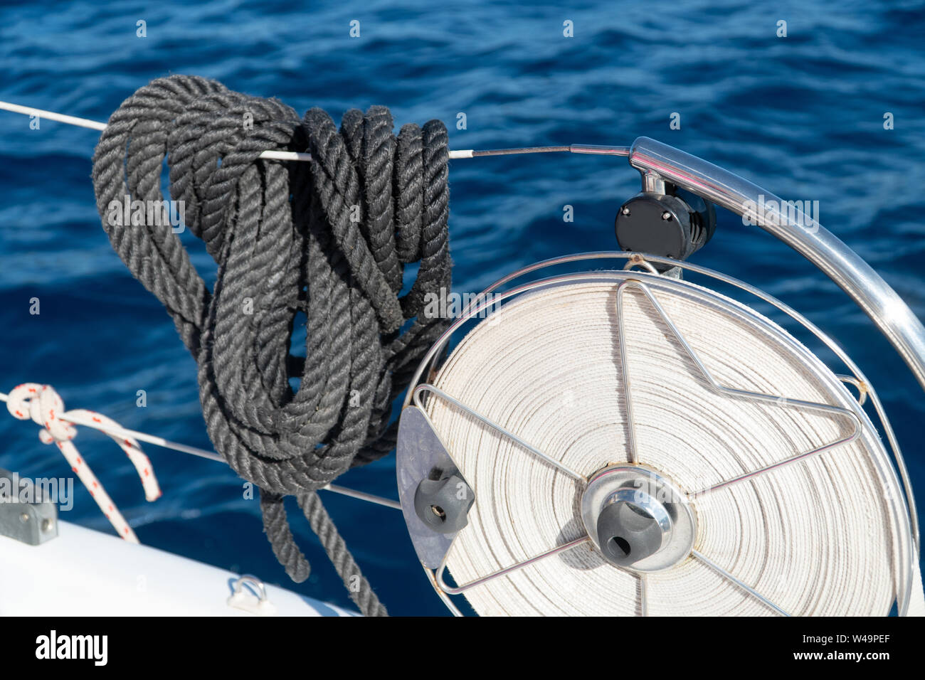 balck mooring lines hanging on the reeling on a sailing yacht Stock