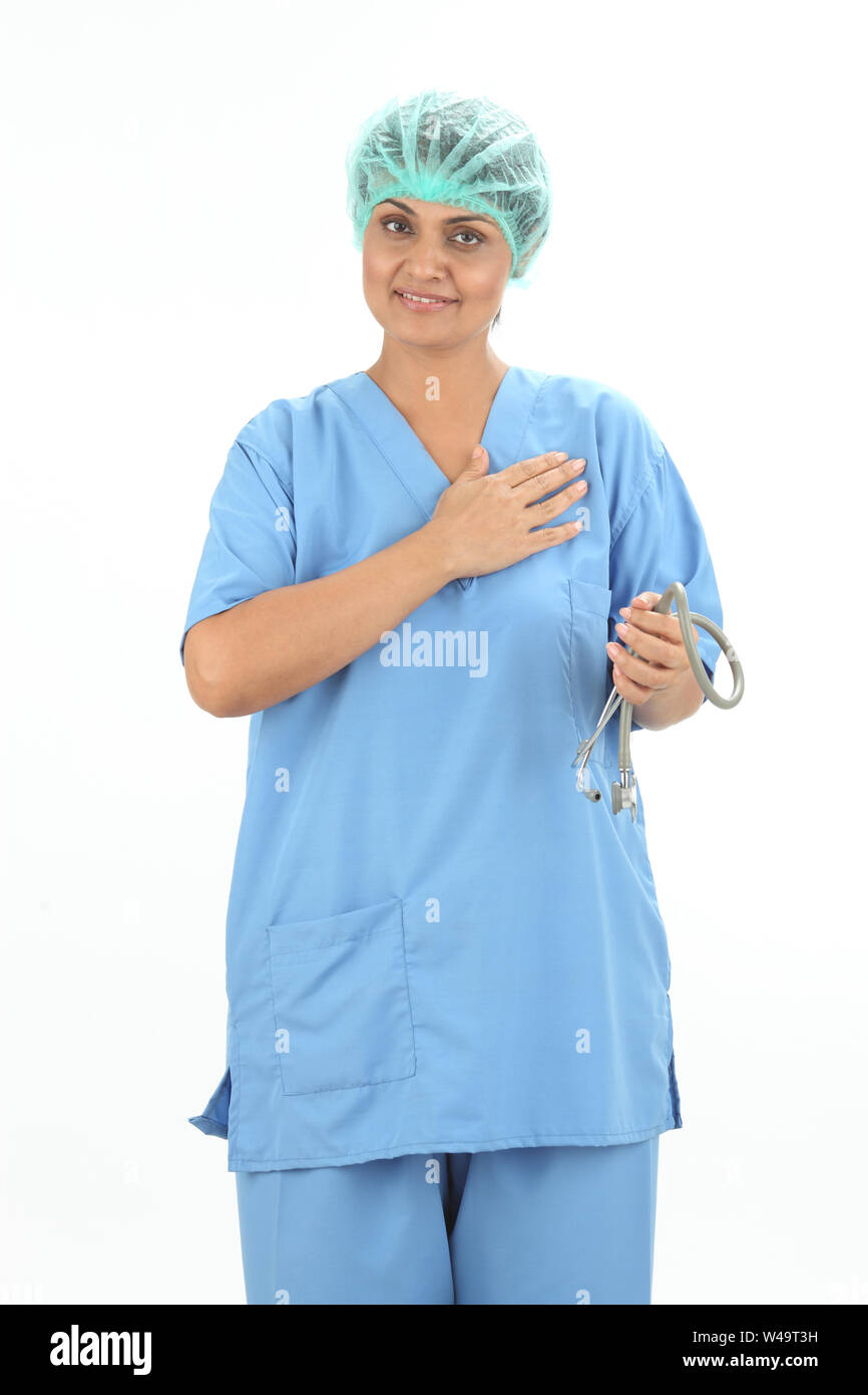 Female doctor smiling with her hand on heart Stock Photo