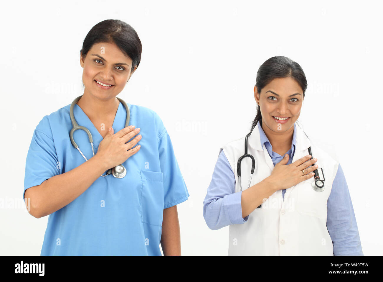 Female doctors smiling with her hand on heart Stock Photo