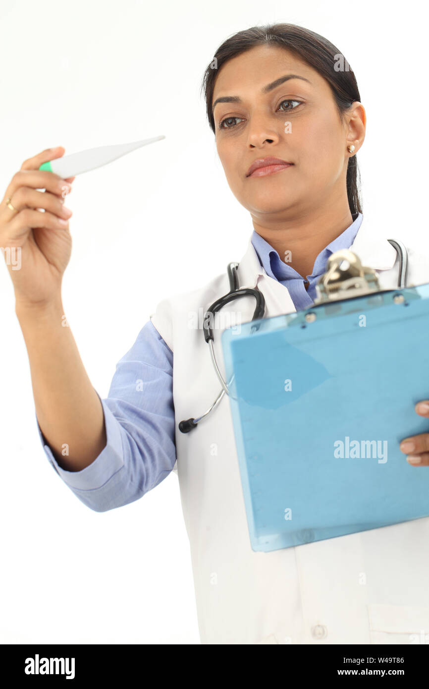 Female doctor checking temperature in digital thermometer Stock Photo