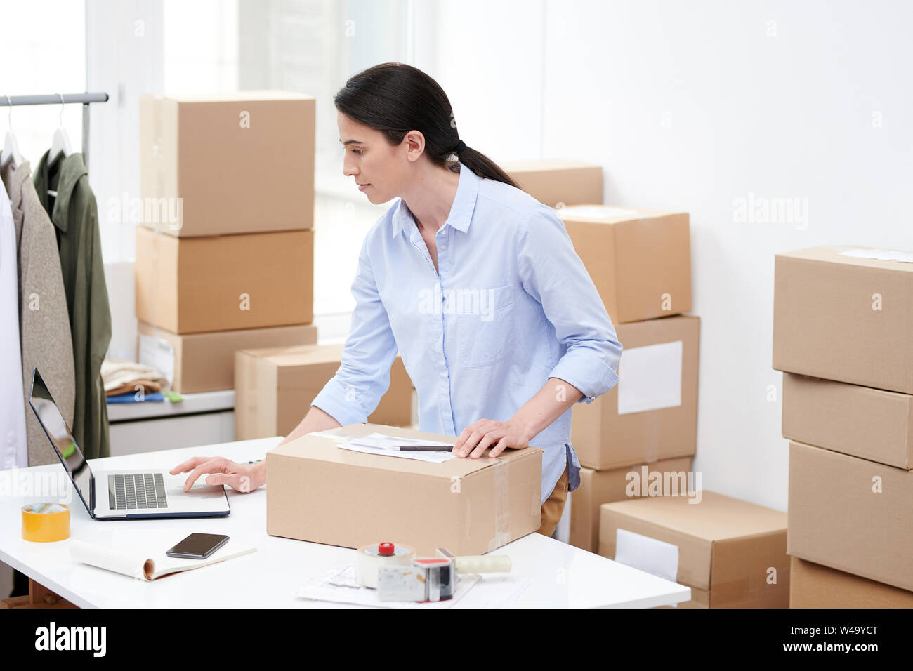 Busy manager of oline shop with packed box looking through order information Stock Photo