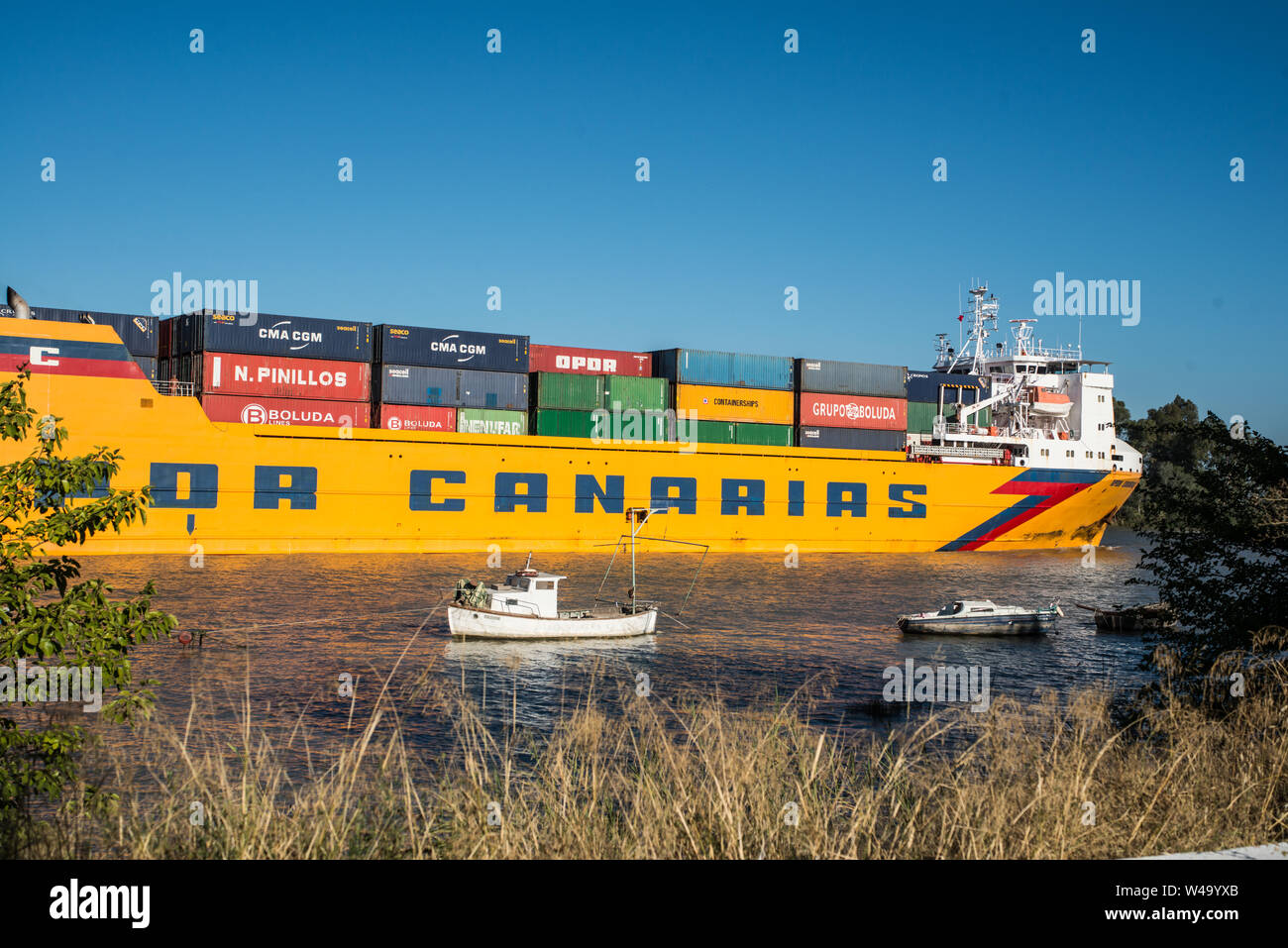 Passage of a cargo ship departed from Sevilla port and navigating Guadalquivir river to the Ocean. Coria del Rio, Andalucia, July 2019 Stock Photo