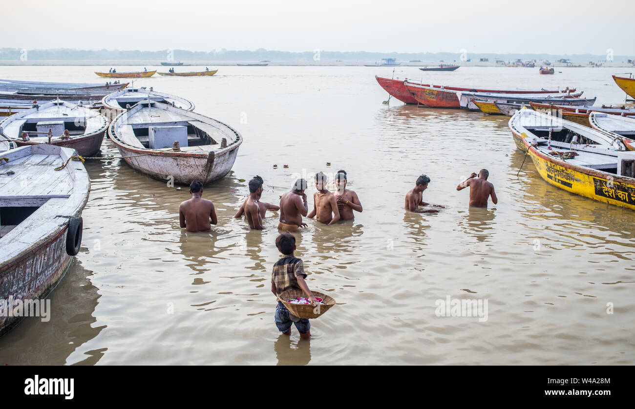 A boy selling flowers for puja offerings in the Ganges river in Varanasi, India. Stock Photo