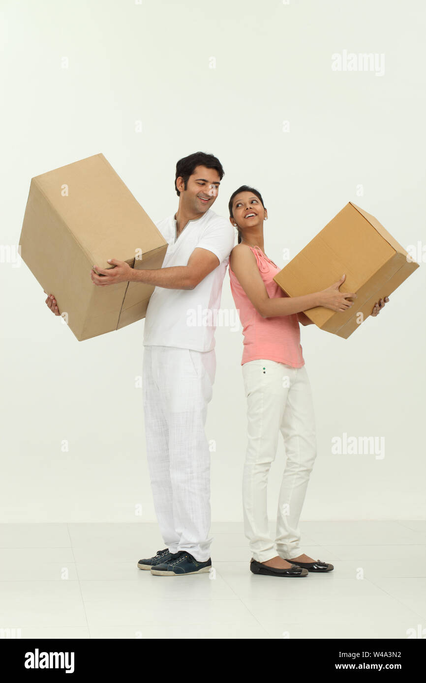 Couple carrying moving boxes into new home Stock Photo - Alamy
