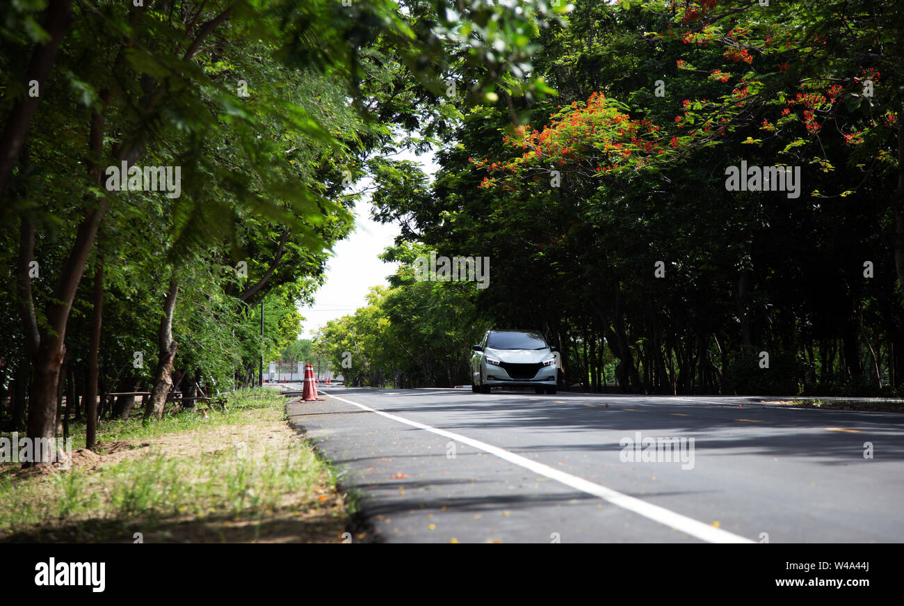electric vihicle driving on road way with green tree like ecology friendly Stock Photo