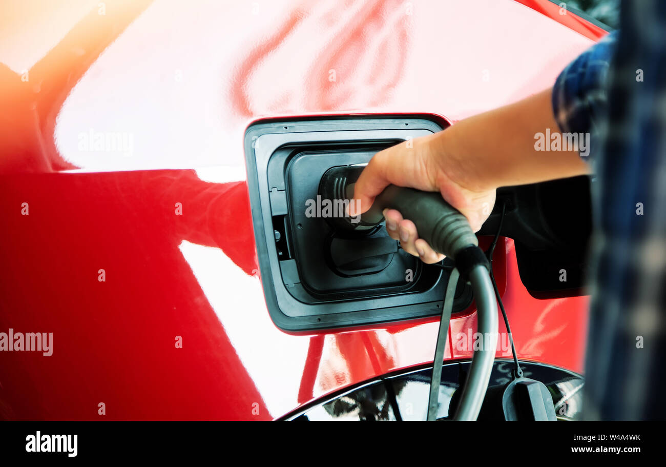 hand hold charge electric vinhicle car for power at station to car Stock Photo