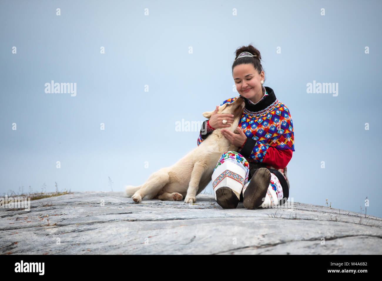 Young inuit woman in traditional clothing posing for photos in a small Greenlandish village. Stock Photo