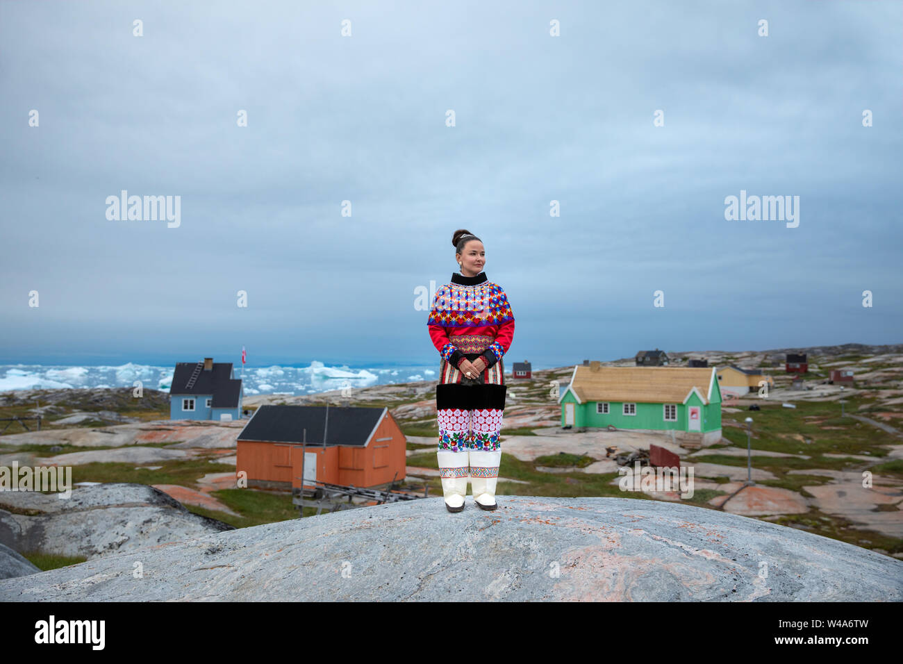 Young inuit woman in traditional clothing posing for photos in a small Greenlandish village. Stock Photo