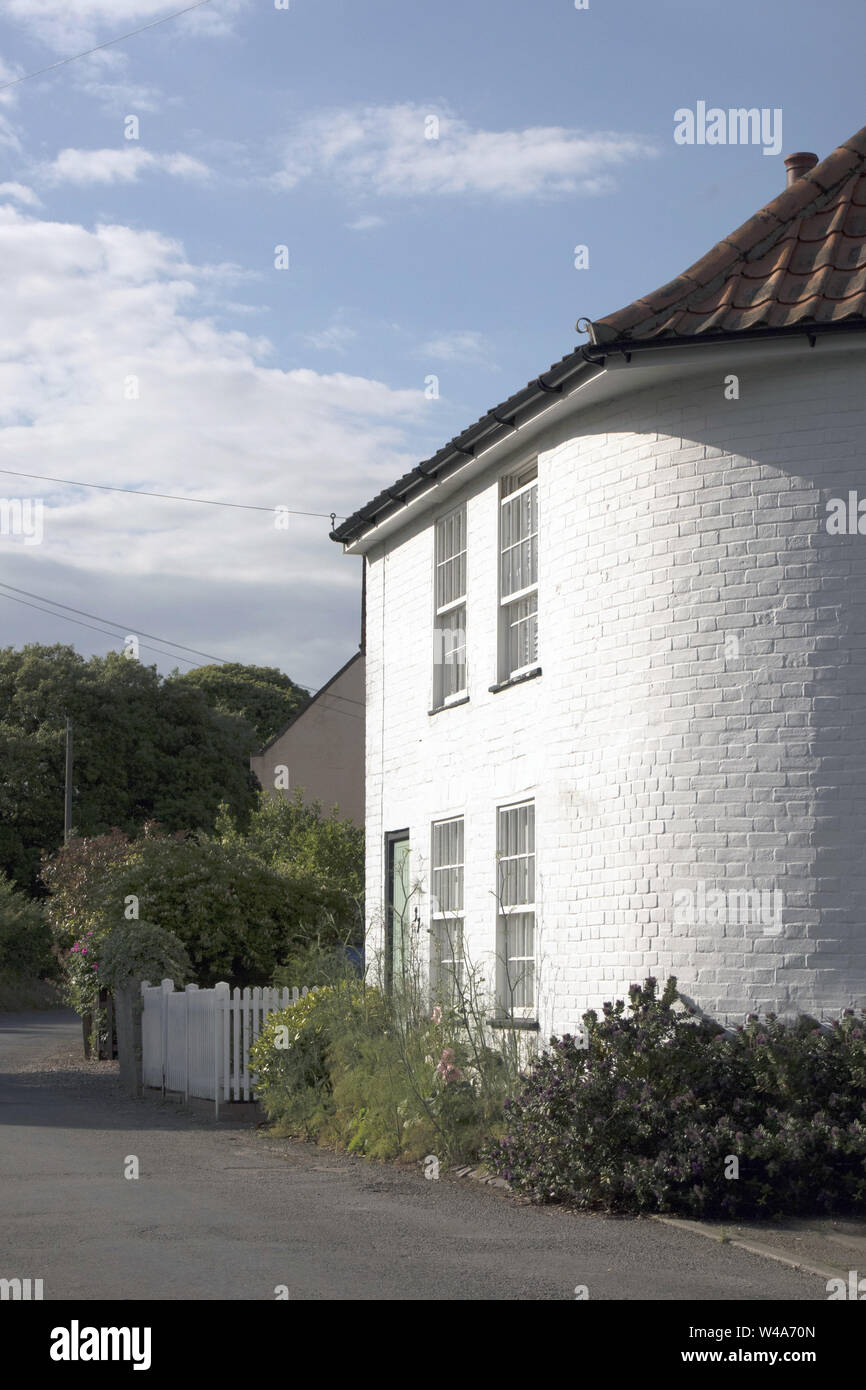 Beautiful white-painted house with a rounded corner in the village of ...