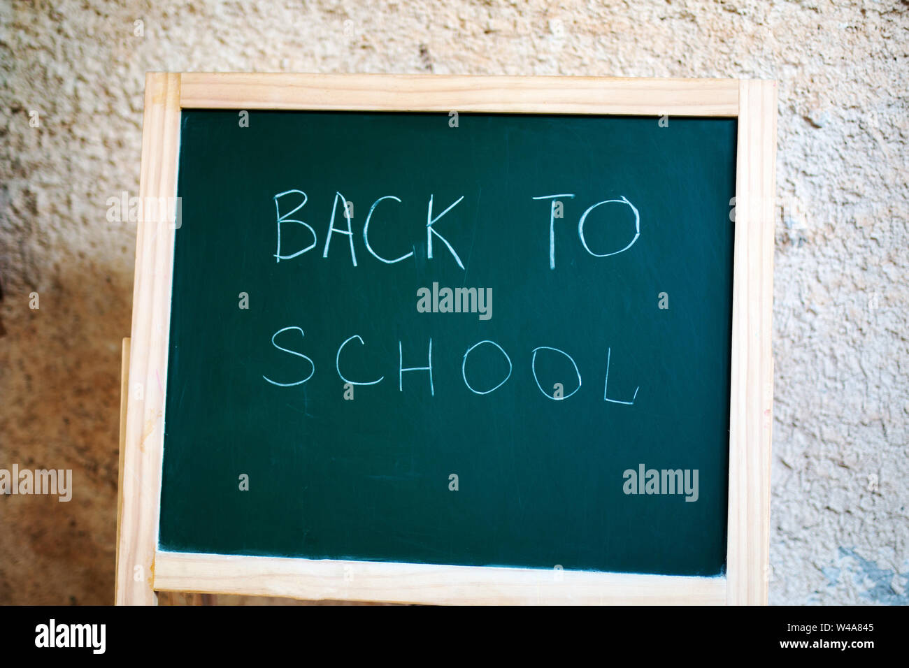 Black school chalkboard on the background of the wall with the inscription back the school Stock Photo
