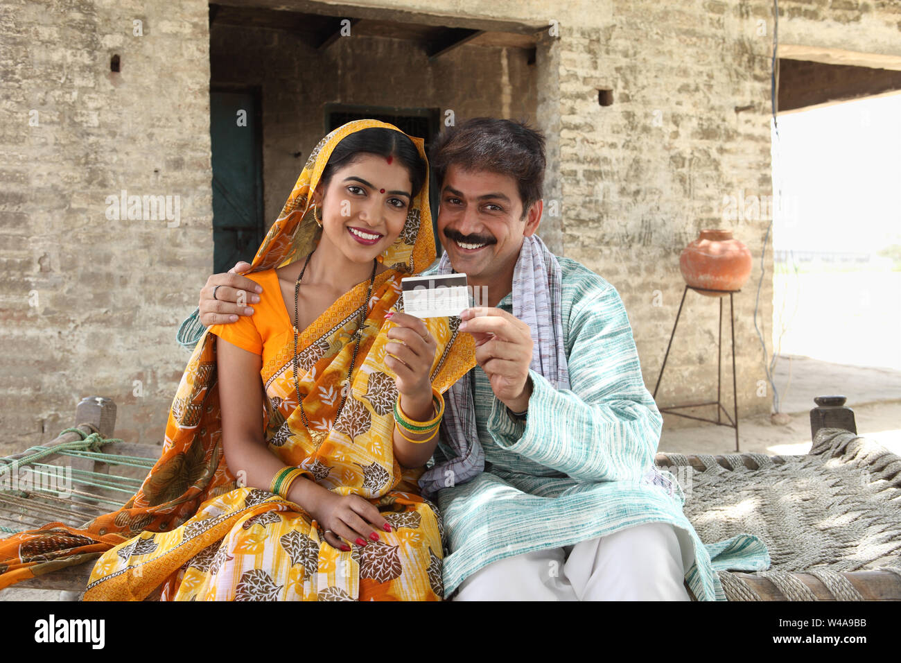 Rural couple showing credit card and smiling Stock Photo - Alamy