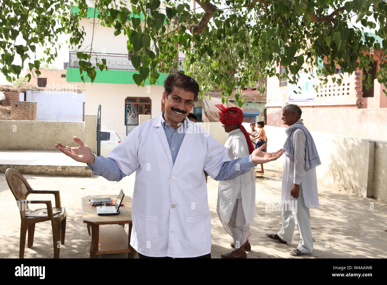Portrait of a male doctor smiling with villagers behind him Stock Photo ...