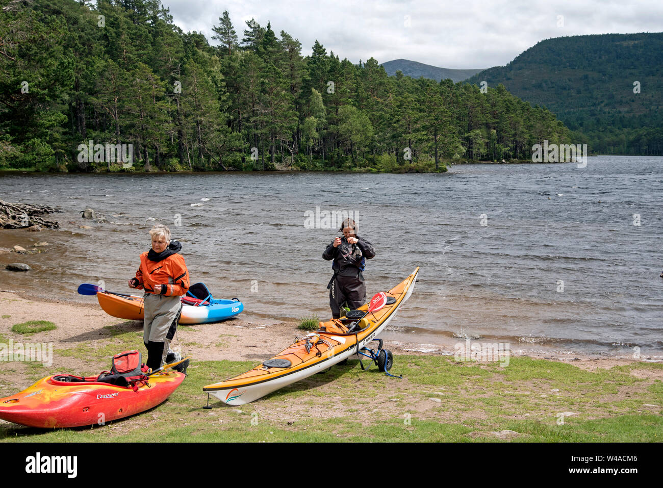 Two kayakers prepare to take to the water at Loch an Eilein in the Cairngorms National Park, Scotland, UK. Stock Photo