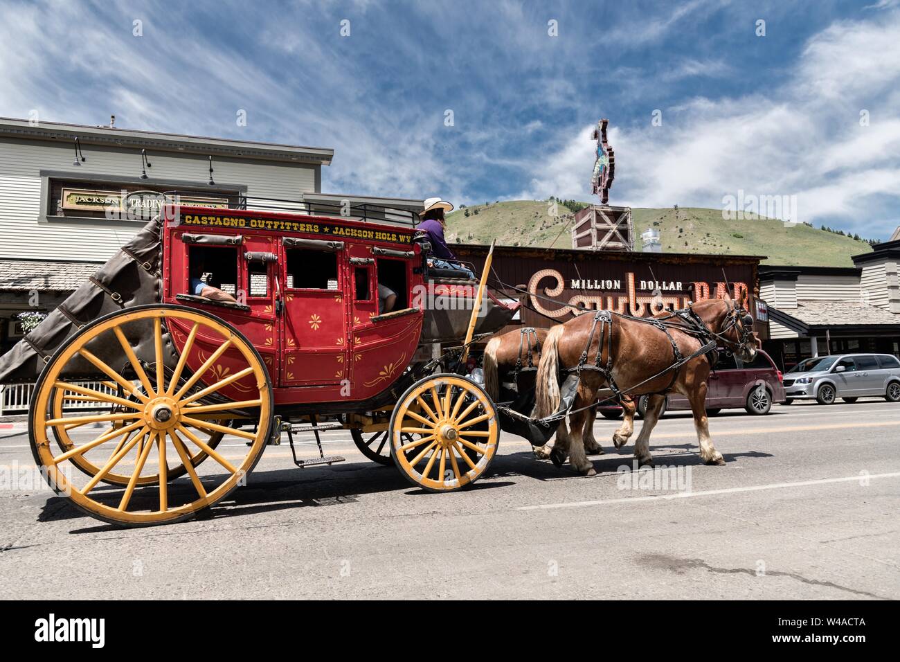 The Castagno Outfitters tourists stagecoach drives past the Million Dollar Cowboy Bar around the the Town Square in Jackson Hole, Wyoming. Stock Photo