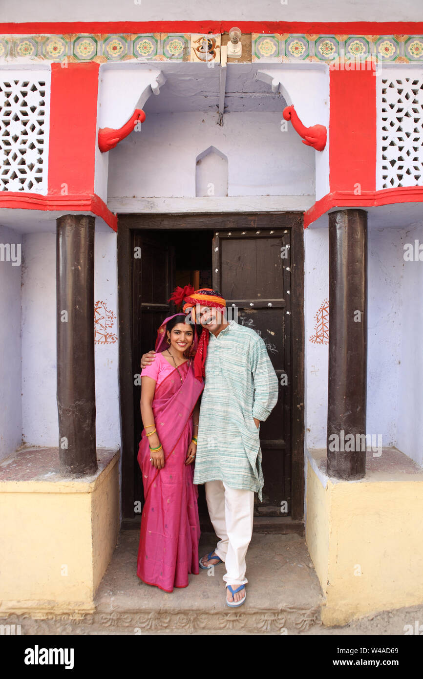 Rural couple standing at entrance of a home and smiling Stock Photo - Alamy