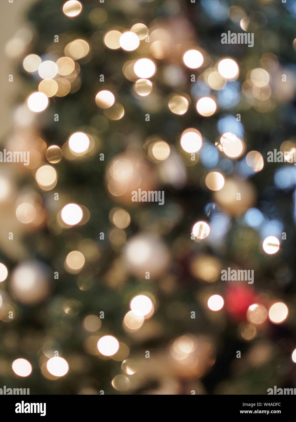 Golden glow of Christmas lights in defocussed with pastel colors showing holiday celebrations and festivities Stock Photo