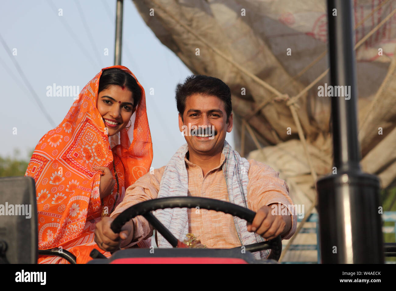 Farmer driving a tractor with his wife sitting beside him Stock Photo ...