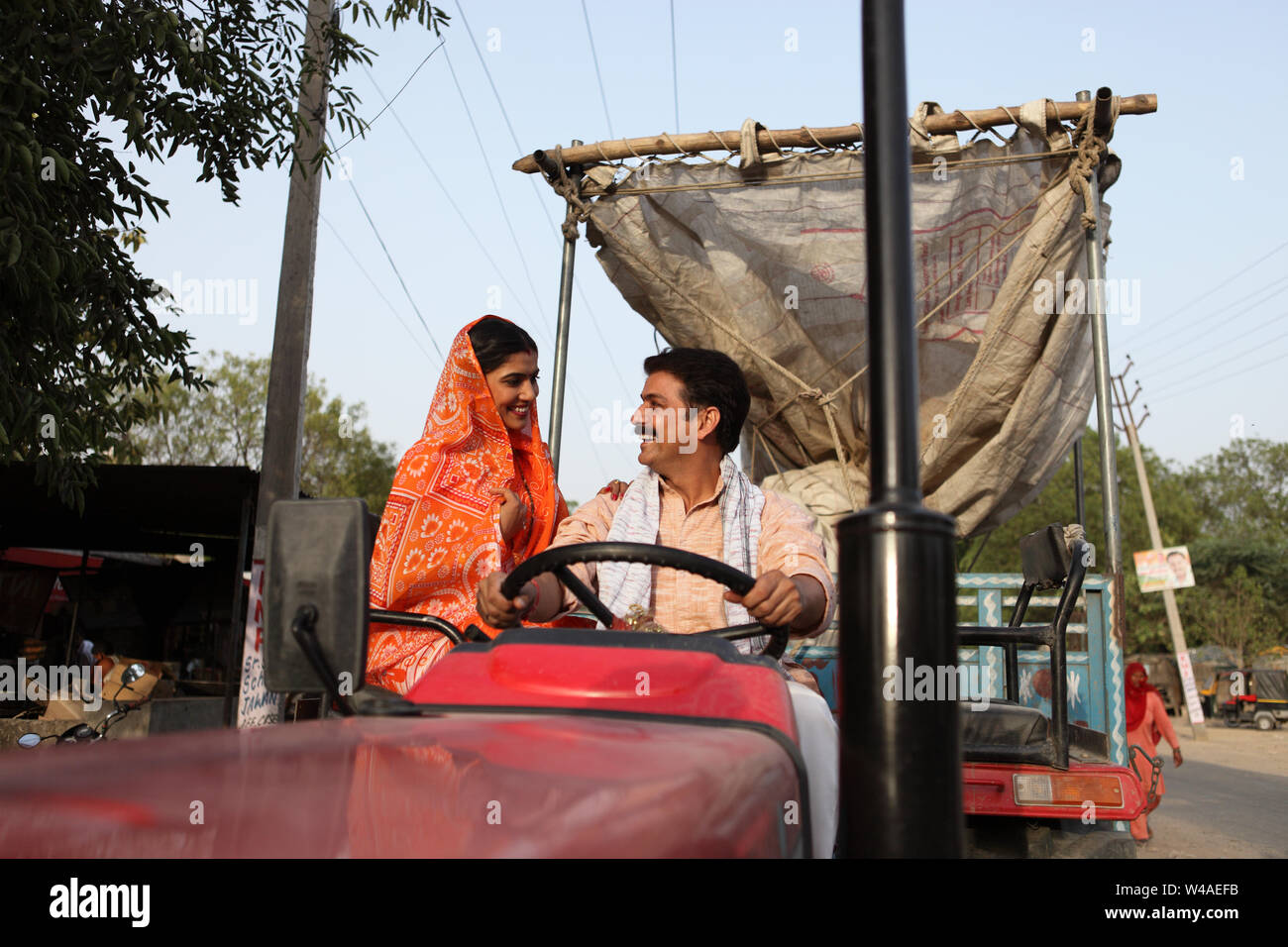 Farmer driving a tractor with his wife sitting beside him Stock Photo ...