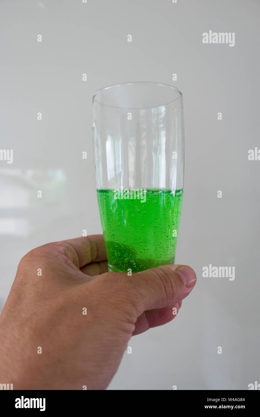 Green viscous liquid in the glass with hand Stock Photo Alamy