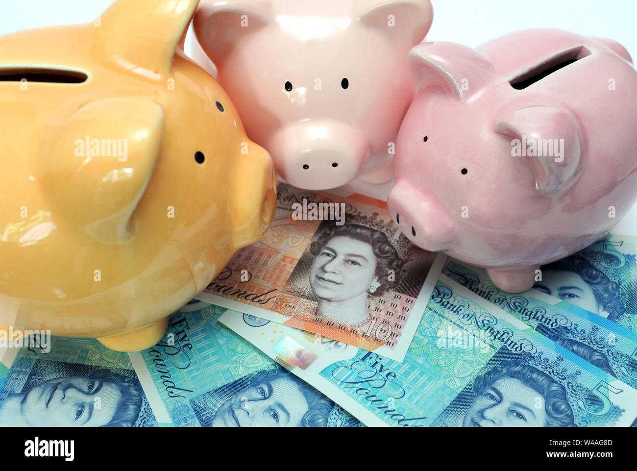 PIGGY BANKS WITH BRITISH MONEY RE MORTGAGES HOUSE BUYING FIRST TIME BUYERS SHOPPERS FINANCE ETC UK Stock Photo