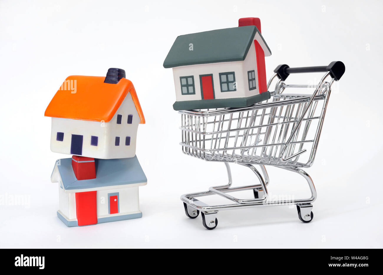 MODEL HOUSES WITH SUPERMARKET SHOPPING TROLLEY RE MORTGAGES HOUSE BUYING FIRST TIME BUYERS SHOPPERS FINANCE ETC UK Stock Photo