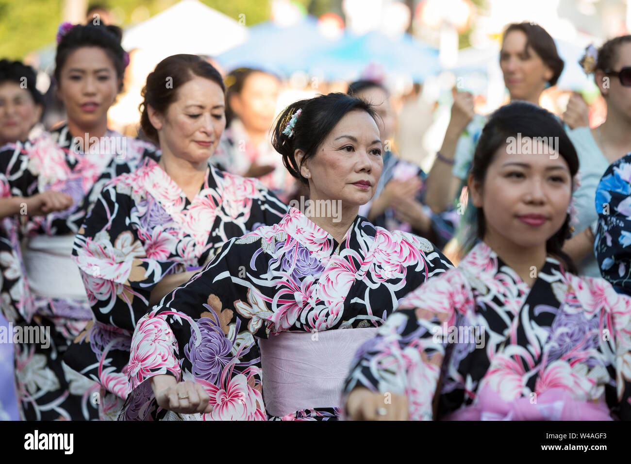 Women wearing traditional yukata robes perform a Bon dance during the 87th annual Bon Odori Festival in Seattle, Washington on July 20, 2019. The lively summer festival features traditional music and folk dance to welcome the spirits of the dead and celebrate the lives of ancestors. Stock Photo