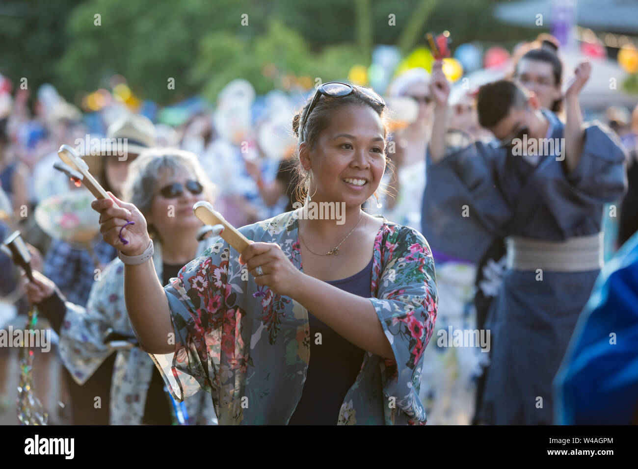Attendees perform a Bon dance with kachi-kachi at the 87th annual Bon Odori Festival in Seattle, Washington on July 20, 2019. The lively summer festival features traditional music and folk dance to welcome the spirits of the dead and celebrate the lives of ancestors. Stock Photo