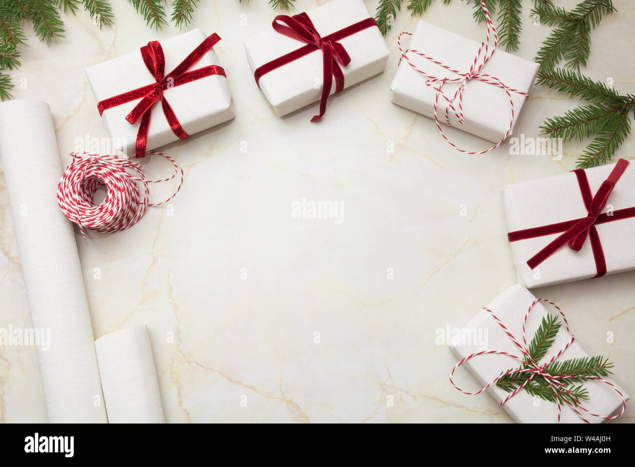 Christmas gift boxes wrapped in white craft paper and decorative red ...
