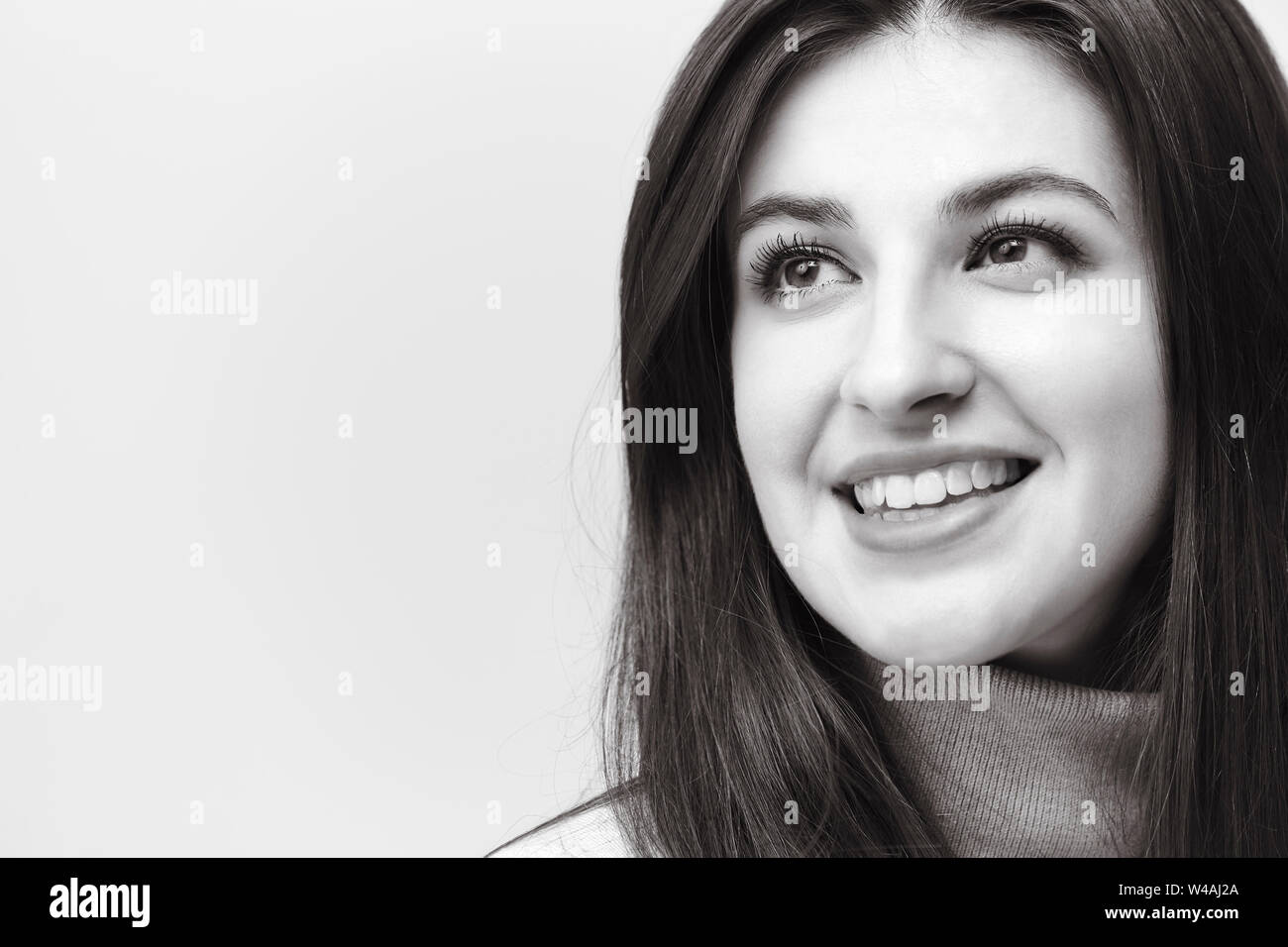 black and white portrait of a beautiful caucasian woman, looking away smiling Stock Photo