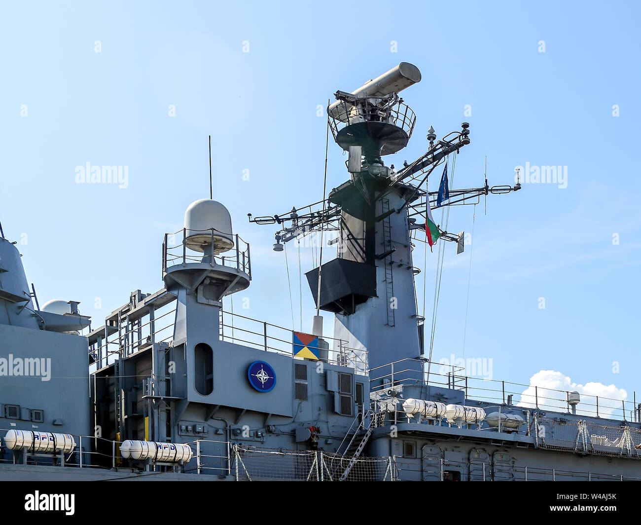 Varna, Bulgaria, July 20, 2019. Fragment of a large gray modern warship with radars and weapons and the blue NATO logo on its side. Stock Photo