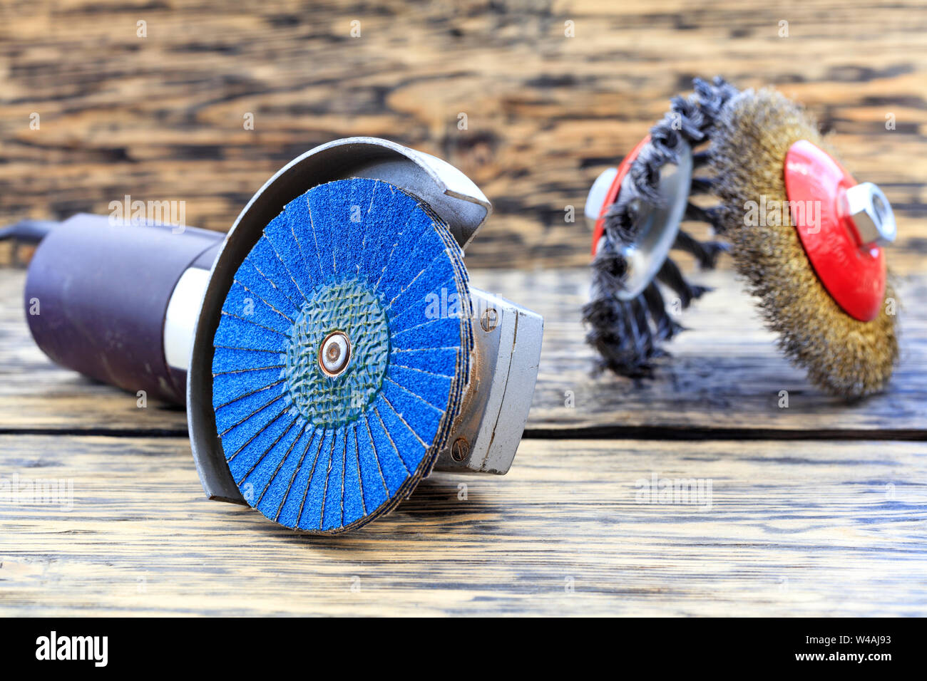 Angle grinder with grinding disc brushes and abrasive wire brushes lies