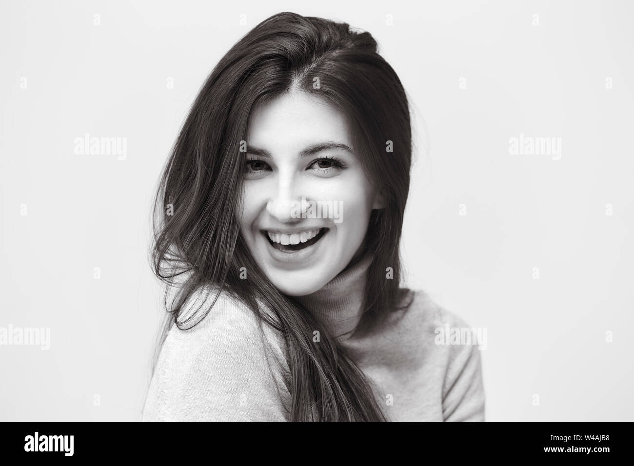 black and white portrait of a beautiful caucasian woman, looking at camera, happy and smiling Stock Photo