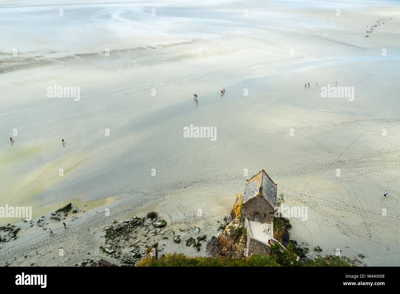 Aerial view of St Aubert chapel and Mont St Michel Bay at low tide with people hiking, Normandy, France. Stock Photo