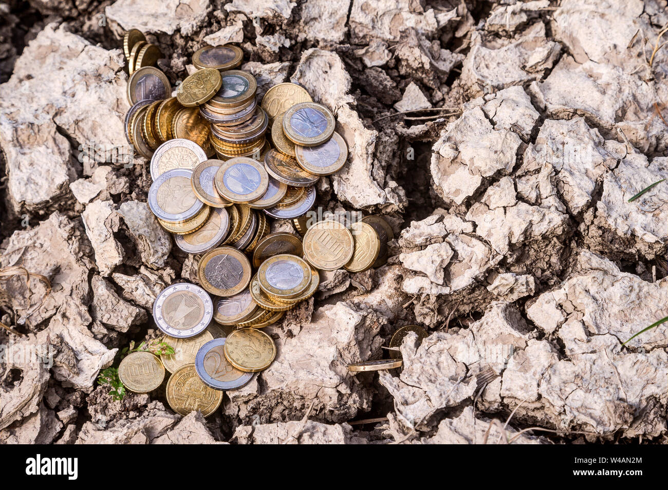 How much does climate change cost? Climate change leads to extreme weather events which cause considerable economic damage. A heap of euro coins lie o Stock Photo