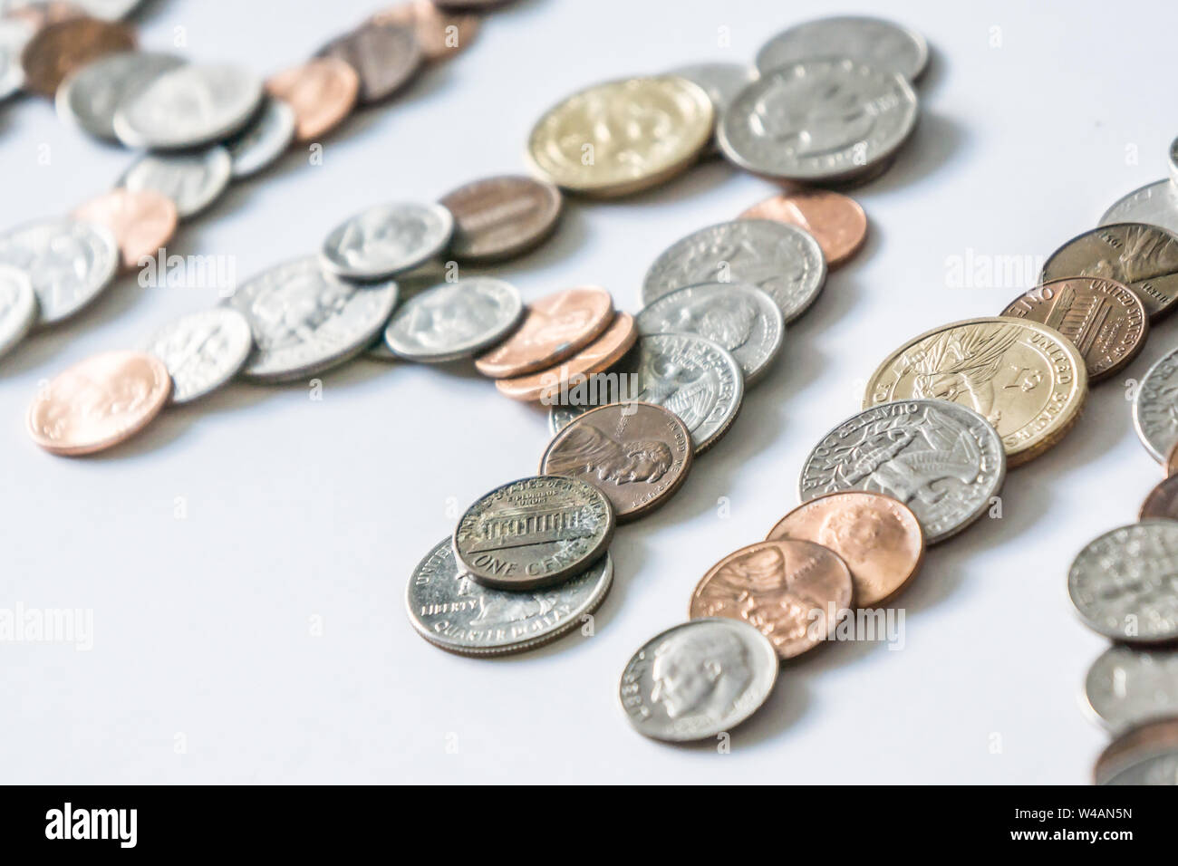Coins isolated on solid white background spelling the word Money from loose coin change. Blank empty room space for text or copy. Financial mockup con Stock Photo