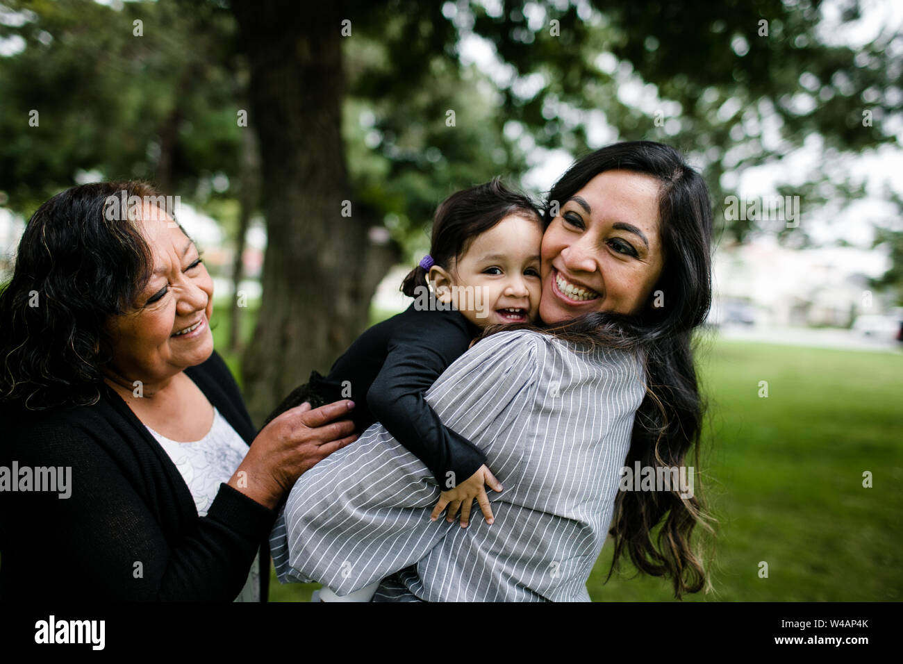 Grandmother, mother & daughter hugging Stock Photo