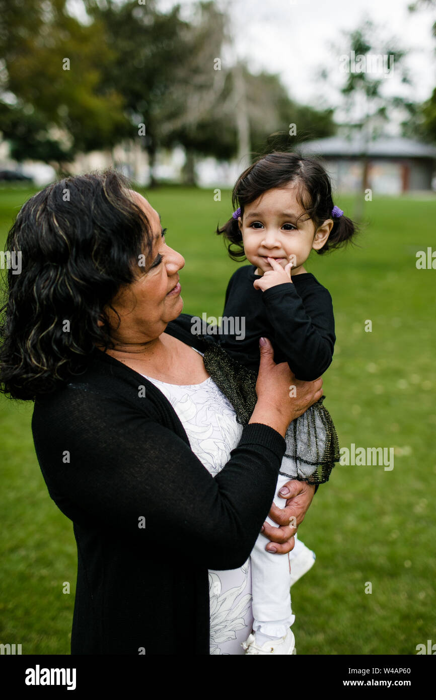 Grandmother looking on at granddaughter in park Stock Photo