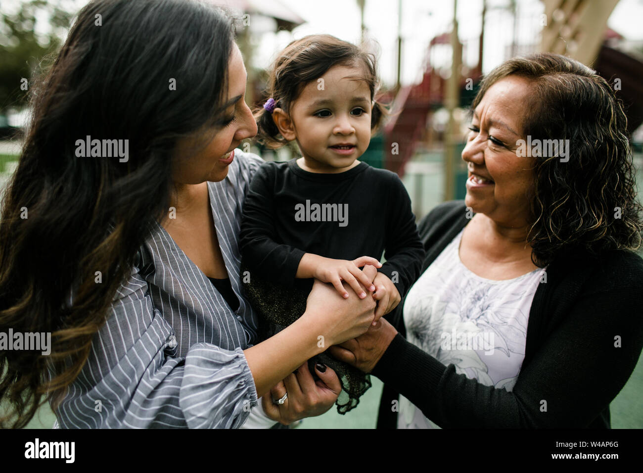 Three generations of women smiling and hugging Stock Photo
