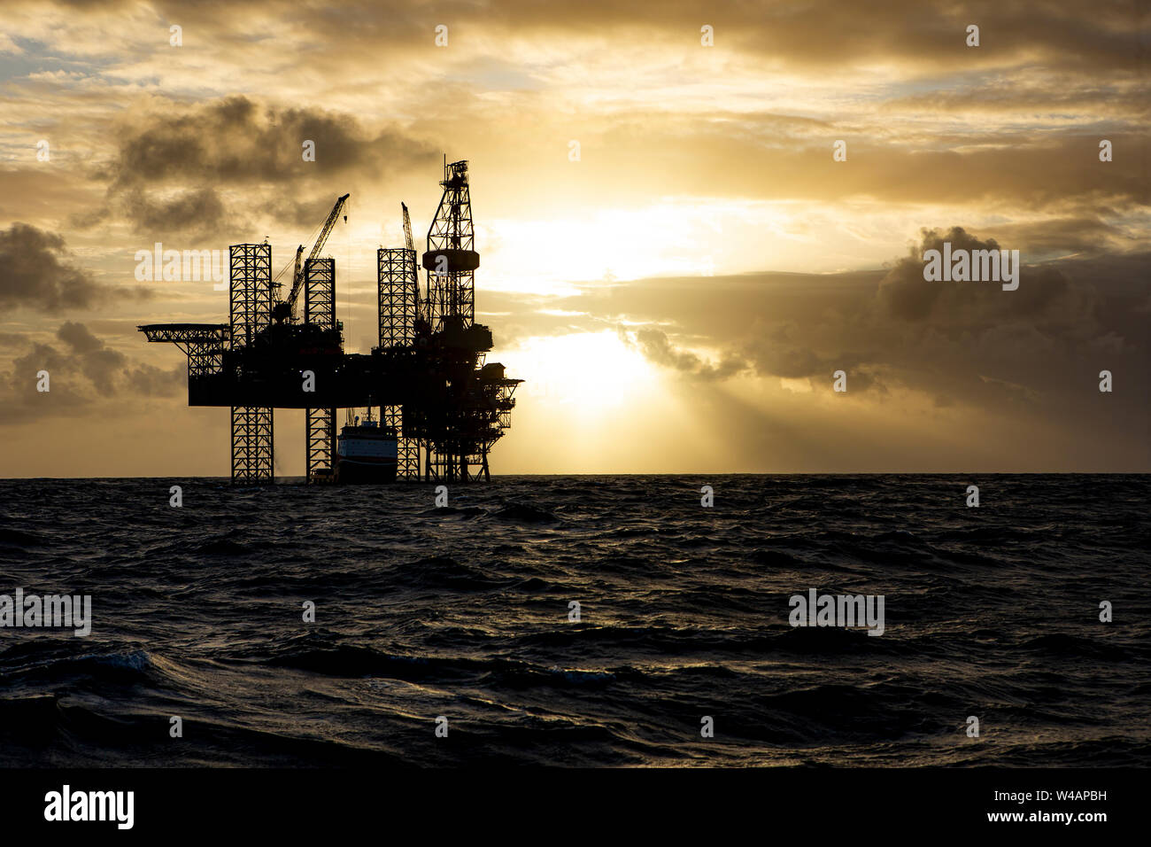 Offshore drilling platform during sunrise Stock Photo
