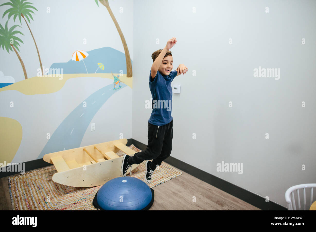 Smiling boy jumps from a sensory bouncer Stock Photo